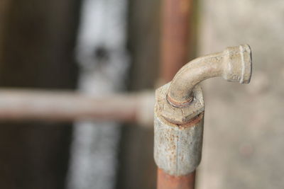 Close-up of old faucet against wall