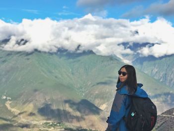 Woman standing on mountain against sky
