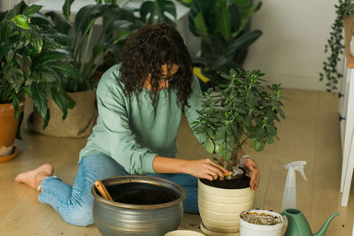 Midsection of woman standing by potted plant