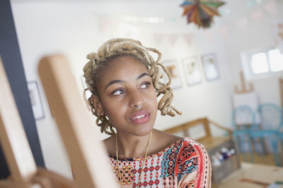 A young woman in front of an easel