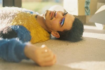 Close-up portrait of man with make-up lying on flooring