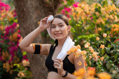 Portrait of smiling young woman with arms raised