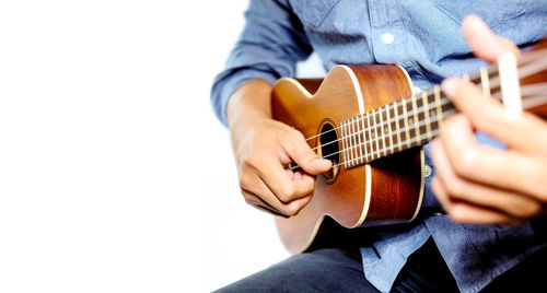 Midsection of man playing guitar