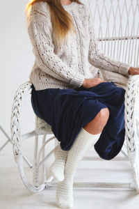 Midsection of woman sitting on chair