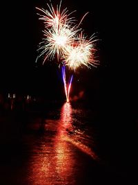 Low angle view of firework display at night