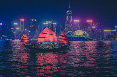 Boats in sea against sky at night