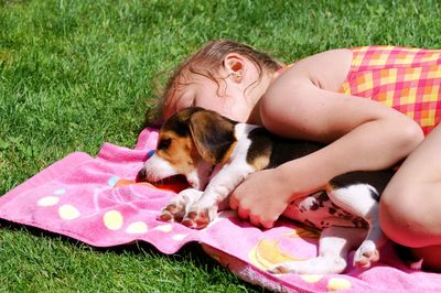 Portrait of young woman with dog on grass