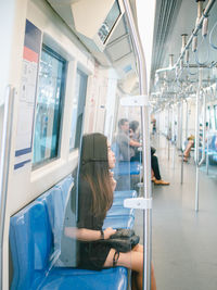 Rear view of woman sitting in train