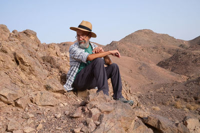 Young man sitting on rock