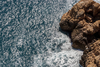 High angle view of rocks on sea shore