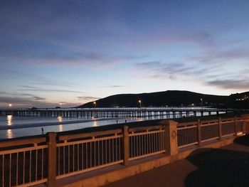 Bridge over sea against sky at night
