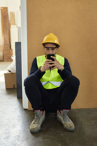 Worker using cell phone during a break in factory