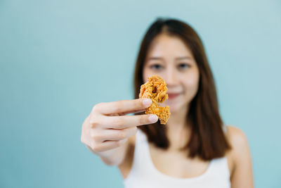 Close-up of woman eating food over white background