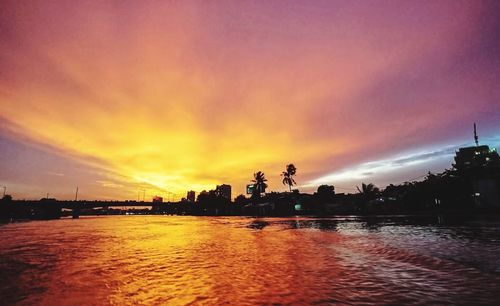 Scenic view of river against sky at sunset