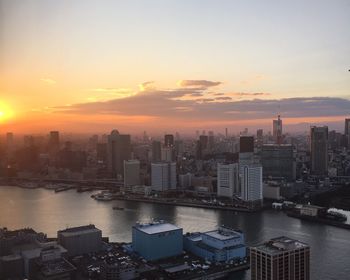 High angle view of city at sunset by waterfront