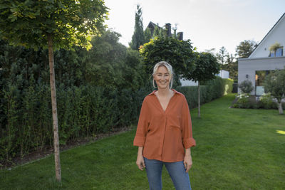 Smiling woman standing in back yard
