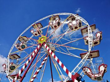 Low angle view of ferris wheel against blue sky during sunny day