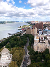 High angle view of cityscape by sea against sky