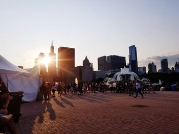 People walking in city at sunset