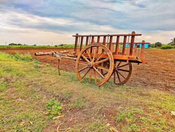 Bullock cart parked on field against sky