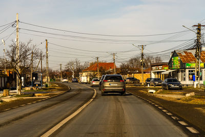 Cars on road in city against sky