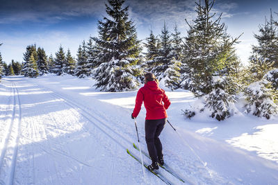 Rear view of person on snow field against sky