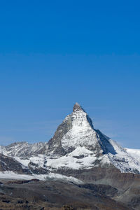 Scenic view of snowcapped mountain against blue sky