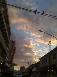 Low angle view of buildings against cloudy sky