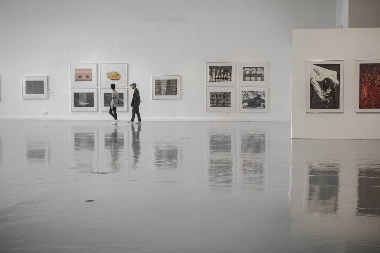 MAN STANDING IN FRONT OF WALL AT MUSEUM