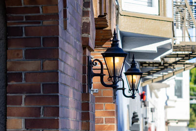 Low angle view of illuminated street light against building