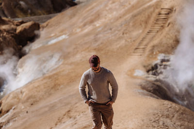 Rear view of man standing on rock