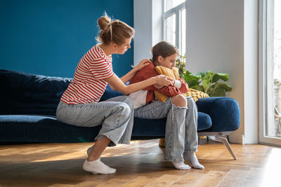 Side view of family sitting on sofa at home