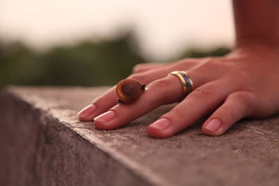 Close-up of woman hand on retaining wall