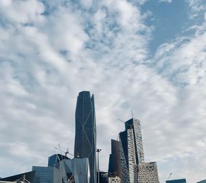 Low angle view of modern buildings against cloudy sky