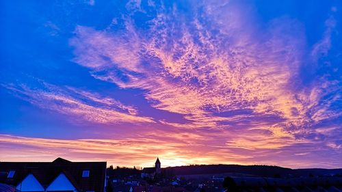 Silhouette buildings against sky at sunset