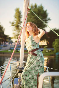 Beautiful woman relaxing on the nose of the yacht at a sunny summer day