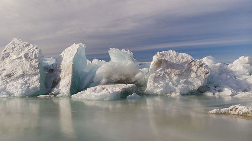 Glacier in lake against sky