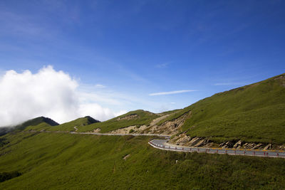 Scenic view of agricultural landscape against blue sky