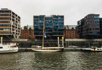 Boats sailing in city against sky