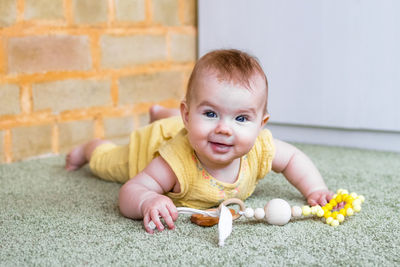 Little girl is playing with wooden and silicon teething toy. concept of teeth health for kids. 