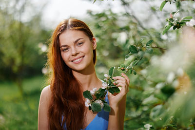 Portrait of young woman holding flowers