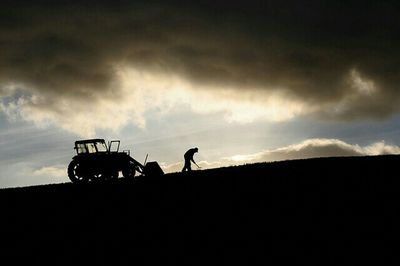 Silhouette of people against cloudy sky