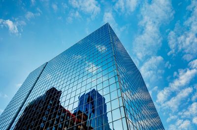 Low angle view of modern office building against blue sky