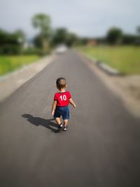 Full length of boy jumping on road