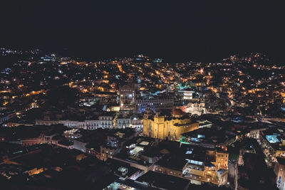 Aerial view of illuminated cityscape against sky at night