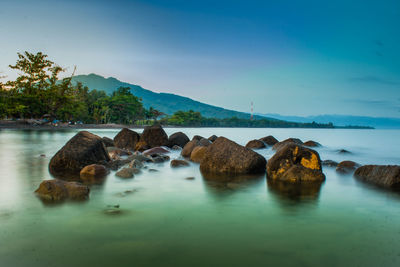 Rocks in sea against sky