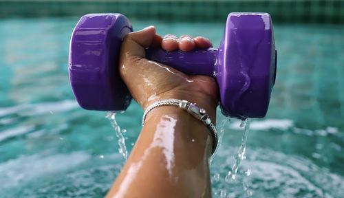 Low section of woman on wet swimming pool