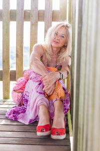 Midsection of woman with pink hair sitting outdoors