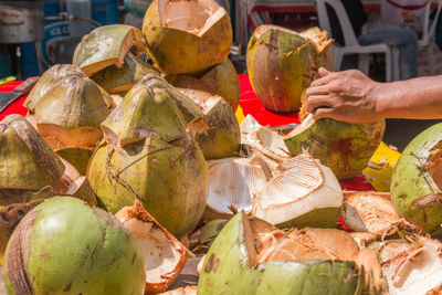 Cropped hands selling coconut