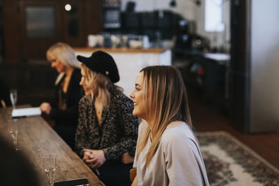 Rear view of woman with people on table